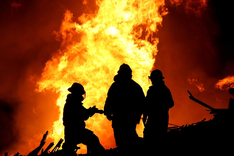 firefighters trying to put out a large fire