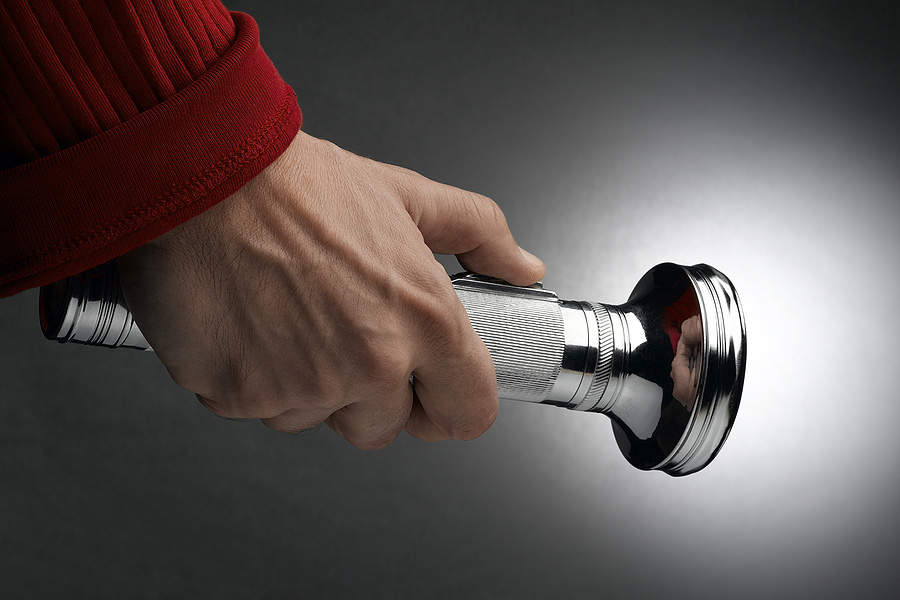 Person holding a lit up flashlight