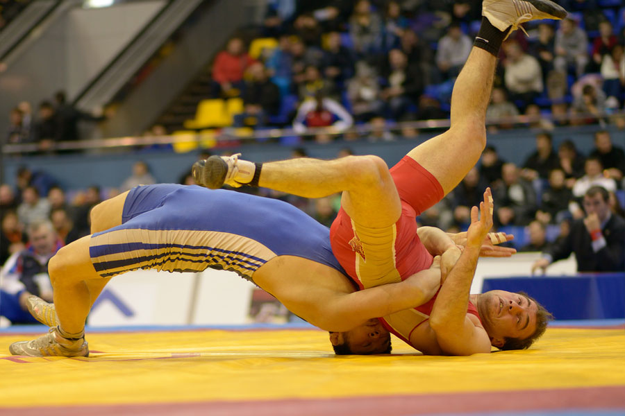 To men wrestling on a mat