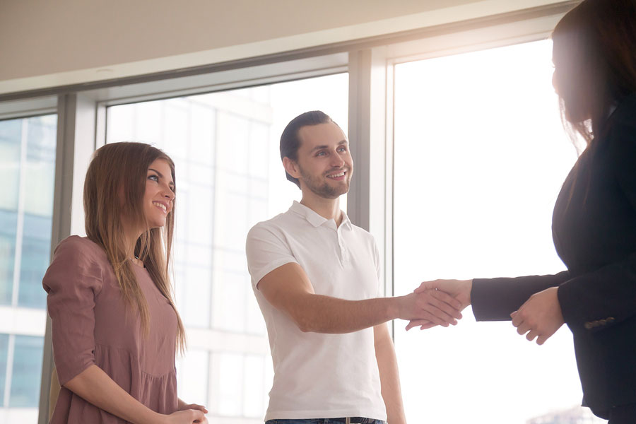 Man standing by woman shaking hands