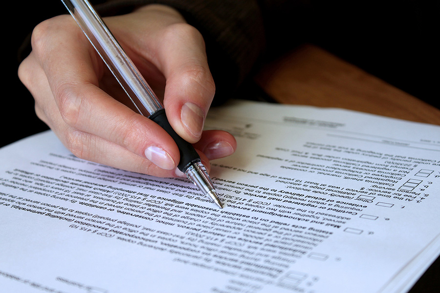 Person writing on legal documents