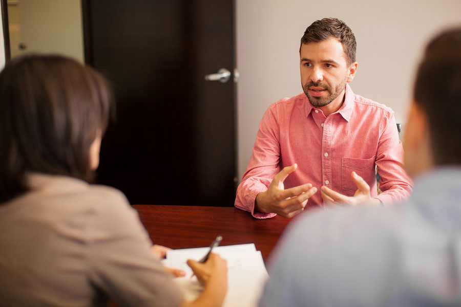 Man speaking with a couple at a table